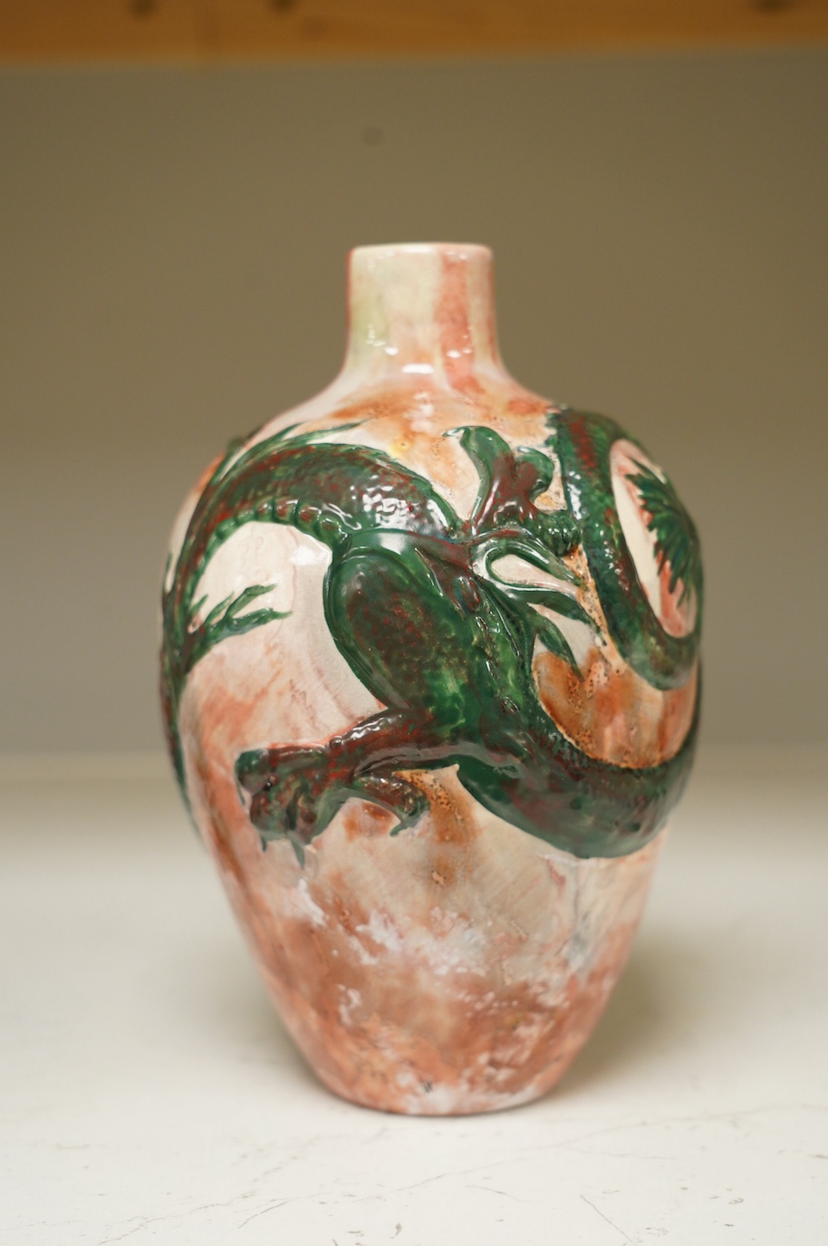 A Bretby impasto vase with raised dragon's head and body, flambé style glaze, impressed Bretby 2761?, 20cm high. Condition - good